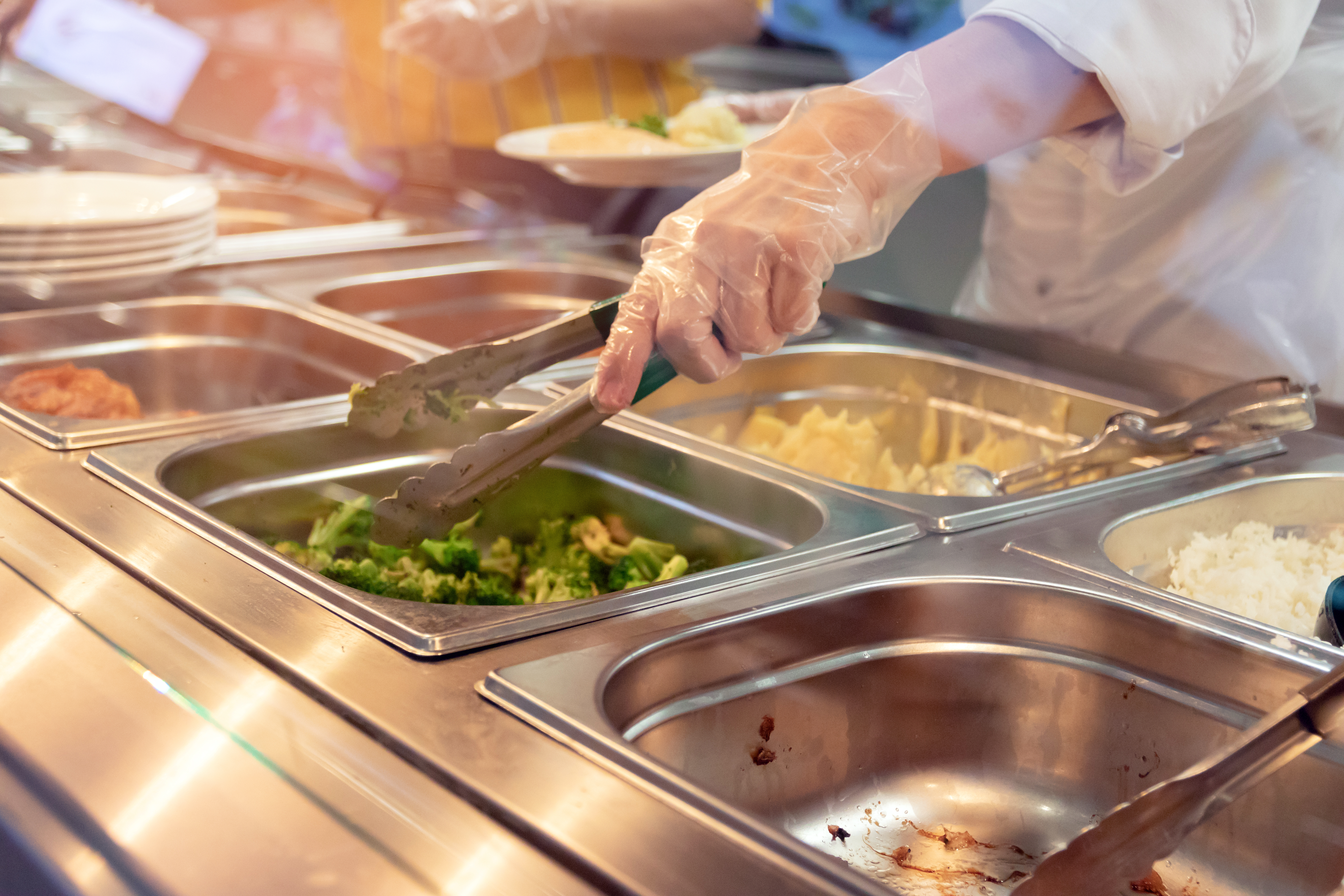 a worker with a glove on serving food