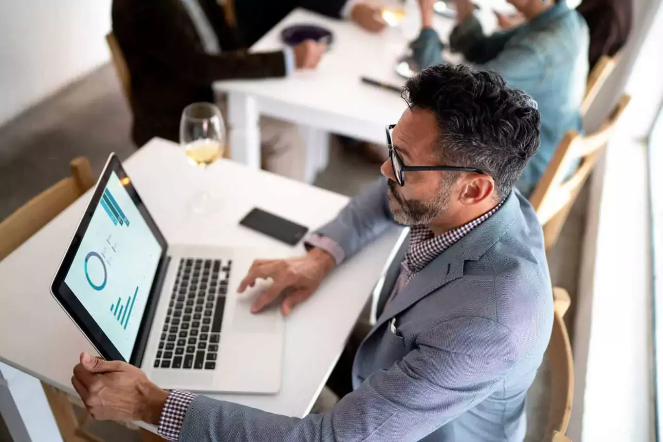 PERSON SITTING IN FRONT OF A LAPTOP