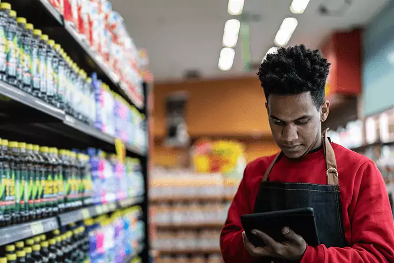 grocery store worker using a tablet