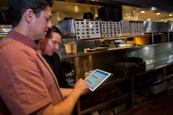 two employees working on a tablet