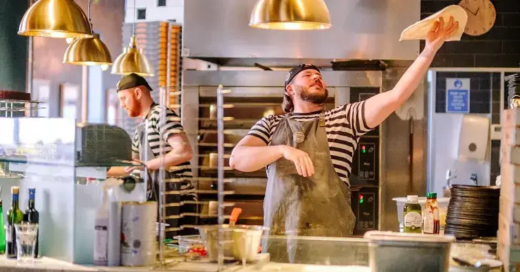 employees making pizza