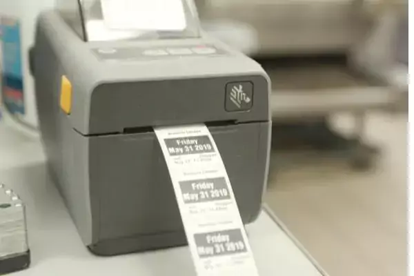 A label printer printing use-by stickers for prepped food