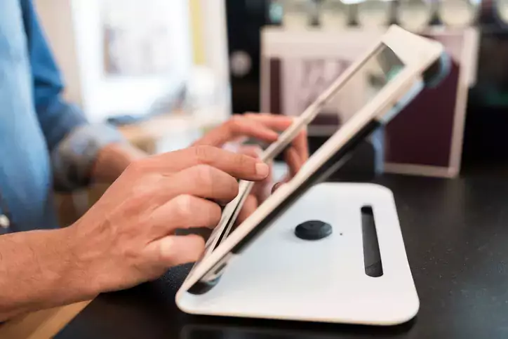 In restaurant the waiter prepares the bill on tablet pc